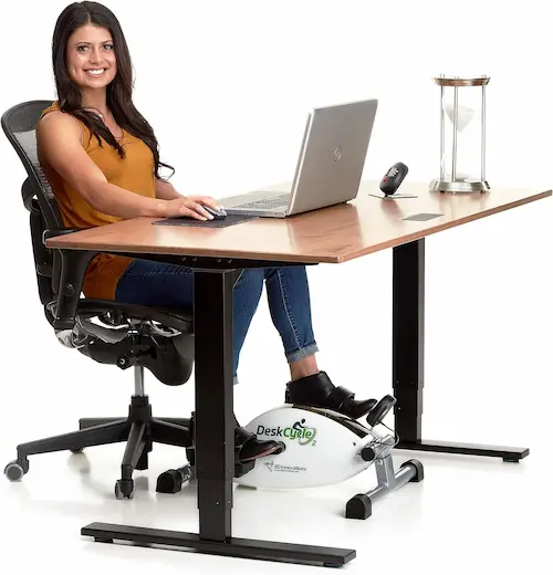 Lady sitting at a desk demonstrating the desk cycle machine